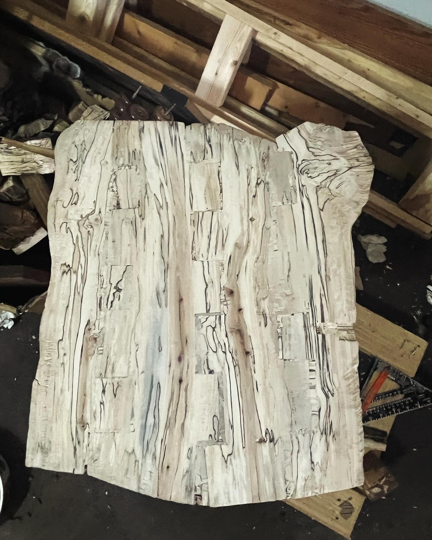 A pale, naturally figured wood slab in the workshop